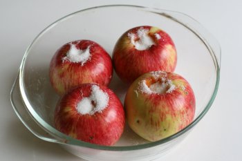 уложить яблоки в посуду для запекания, в отверстие насыпать сахар, сбрызнуть водой