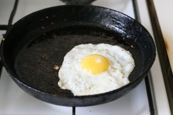 сделать глазунью, для этого на сковороду с жиром вылить яйцо, стараясь не разорвать желток, жарить до состояния, чтобы затвердел белок, желток должен остаться жидким