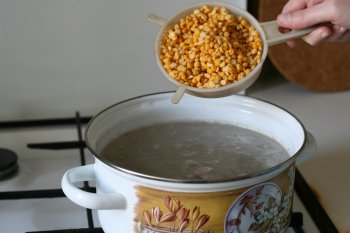 сваренный бульон процедить, добавить промытый горох, белый соус, томатную пасту, соль и специи