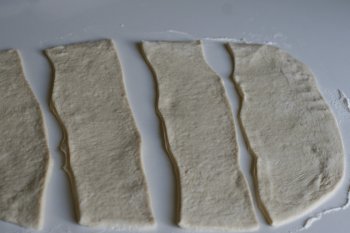 разрезать тесто на длинные полосы шириной 12-13 см