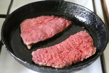 мясо посыпать солью и перцем, положить на сковороду или в сотейник с сильно нагретым топленым говяжьим салом