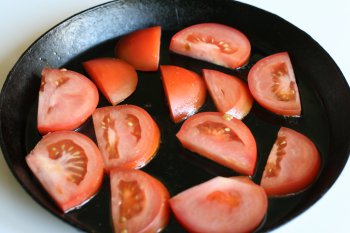 помидоры нарезать дольками, посолить их, добавить перец и растертый чеснок