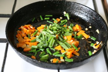 положить зеленый лук на сковороду с морковью, слегка потушить