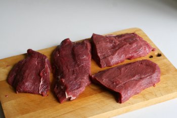 нарезать мясо на порционные куски, слегка отбить