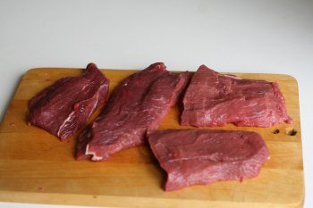 нарезать мясо на порционные куски и слегка отбить, посолить и поперчить