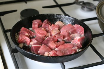 к луку отправить мясо и жарить до готовности, добавить томат-пасту и прокипятить