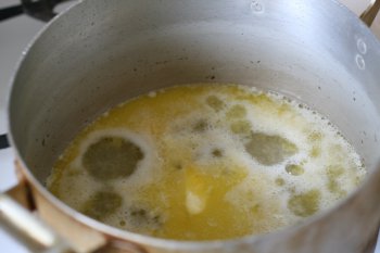 приготовить заварное тесто: в горячую воду положить сливочное масло и довести до кипения