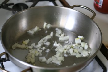 для приготовления томатного соуса сначала нарезать лук и обжарить его на жире