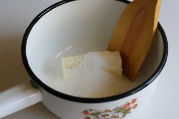 мягкое сливочное масло нарезать на кусочки, добавить сахар, ванилин и взбивать деревянной лопаточкой до однородной кремообразной массы